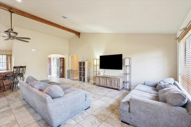 tiled living room with ceiling fan, plenty of natural light, and lofted ceiling with beams