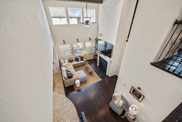 living room with dark hardwood / wood-style flooring and ceiling fan