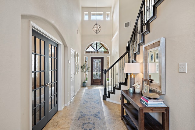 entryway with a notable chandelier and light tile patterned floors