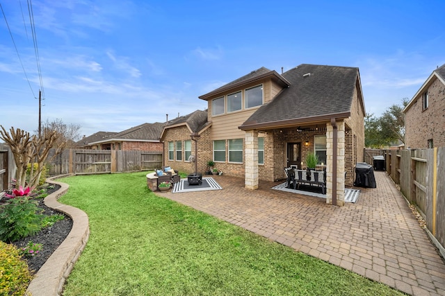 rear view of property with a yard and a patio area