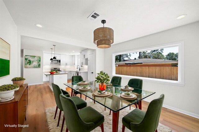 dining room with sink and light wood-type flooring