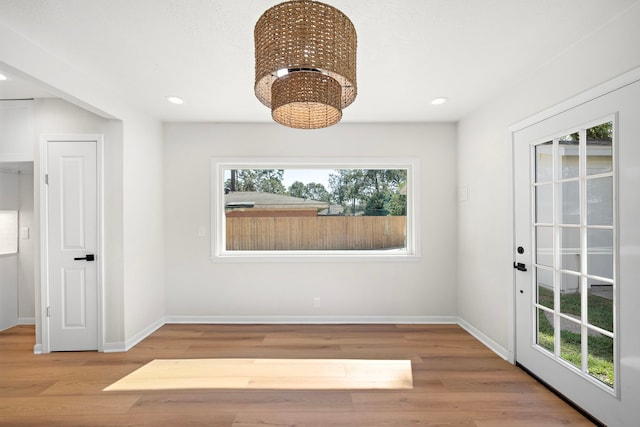 unfurnished dining area with an inviting chandelier and hardwood / wood-style floors