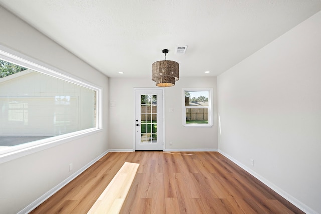 interior space with recessed lighting, visible vents, light wood-style flooring, and baseboards