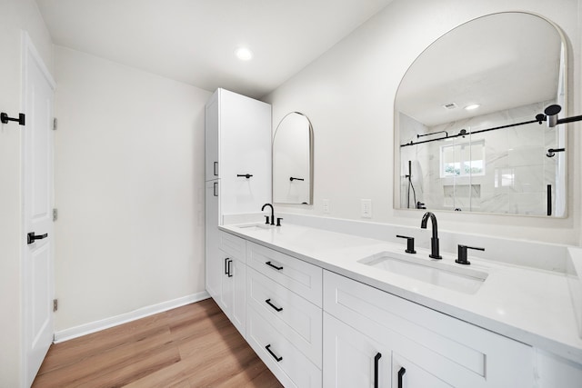 bathroom featuring hardwood / wood-style flooring, vanity, and a shower with door