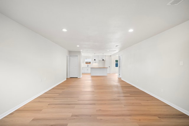 unfurnished living room featuring visible vents, recessed lighting, baseboards, and light wood-style floors