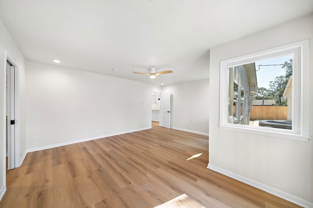 spare room featuring recessed lighting, a ceiling fan, light wood-type flooring, and baseboards