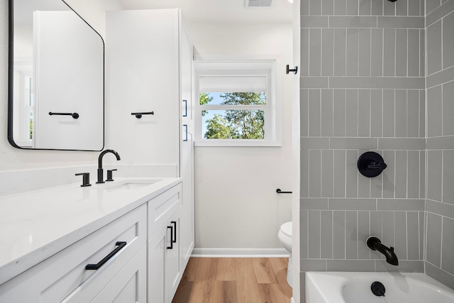 bathroom featuring visible vents, toilet, wood finished floors, baseboards, and vanity