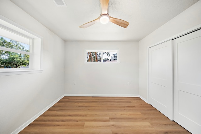 unfurnished bedroom with visible vents, baseboards, ceiling fan, light wood-style floors, and a closet