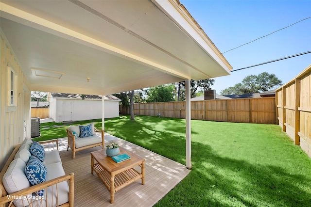 view of yard featuring an outbuilding, outdoor lounge area, a storage shed, and a fenced backyard