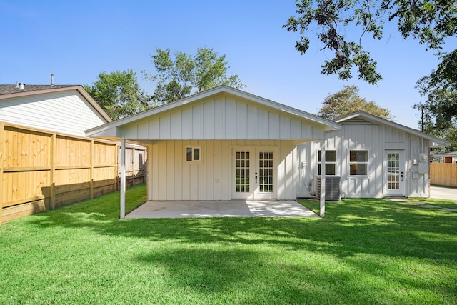 back of house featuring board and batten siding, a yard, french doors, and fence