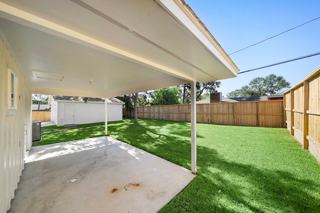 view of yard with a patio area, cooling unit, an outbuilding, and a fenced backyard