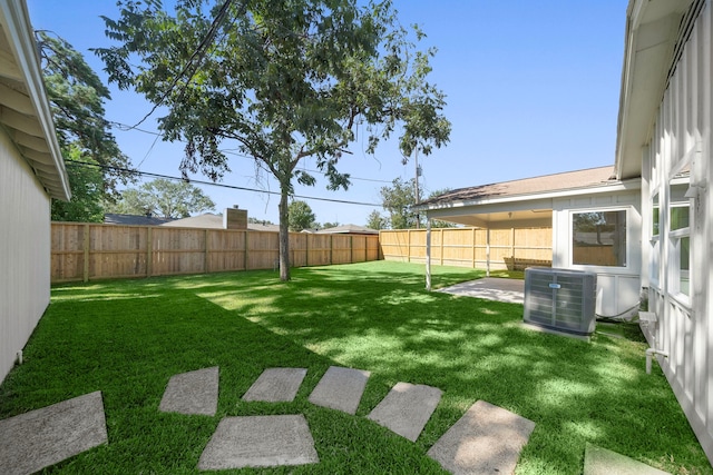 view of yard featuring central air condition unit, a fenced backyard, and a patio area