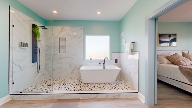 bathroom with tile walls, wood-type flooring, and separate shower and tub