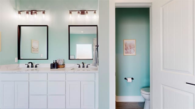 bathroom featuring vanity, hardwood / wood-style flooring, and toilet