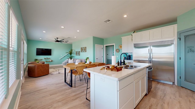 kitchen featuring white cabinetry, an island with sink, appliances with stainless steel finishes, and sink