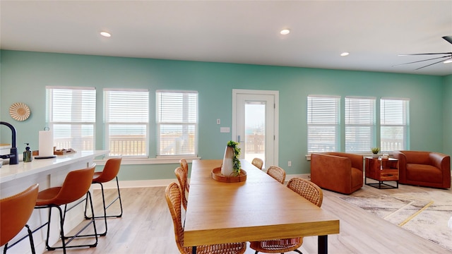 dining area with ceiling fan, light hardwood / wood-style floors, and a wealth of natural light