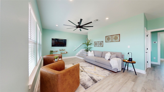 living room with ceiling fan and light hardwood / wood-style flooring