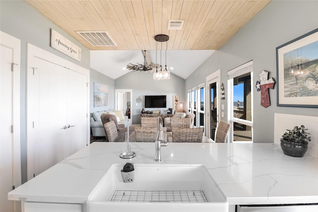 kitchen featuring vaulted ceiling, sink, hanging light fixtures, wood ceiling, and light stone counters