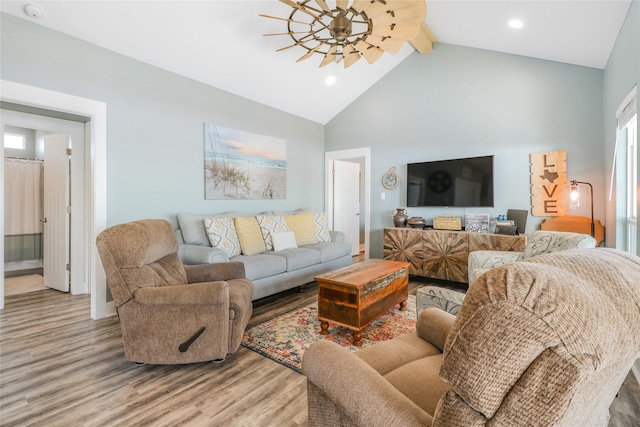 living room featuring hardwood / wood-style floors, beam ceiling, high vaulted ceiling, and ceiling fan