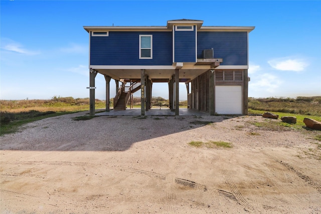 rear view of property with a carport and a garage