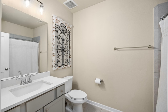 bathroom featuring tile patterned flooring, vanity, toilet, and walk in shower