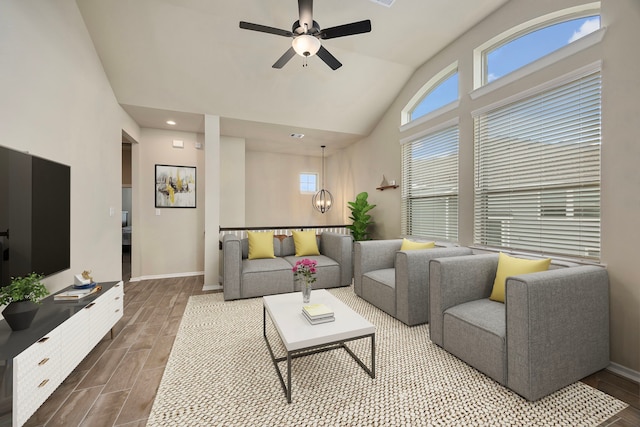 living room with ceiling fan with notable chandelier and high vaulted ceiling