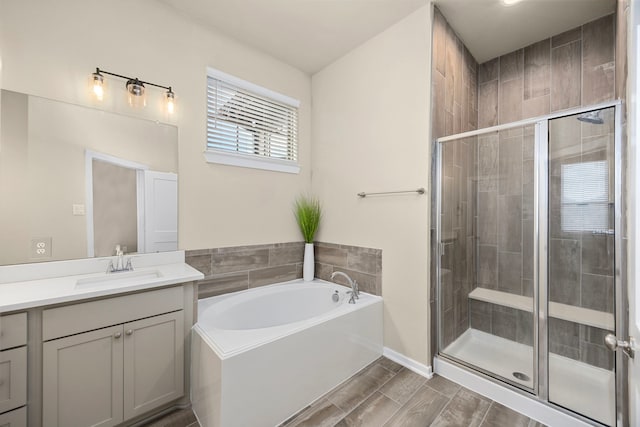 bathroom with vanity and shower with separate bathtub