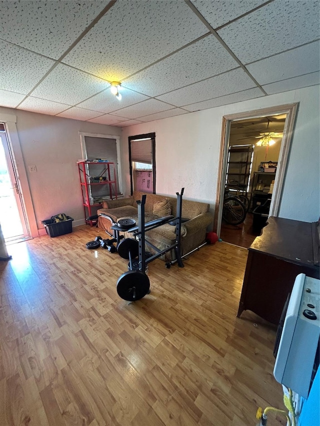 workout room with a drop ceiling and hardwood / wood-style flooring