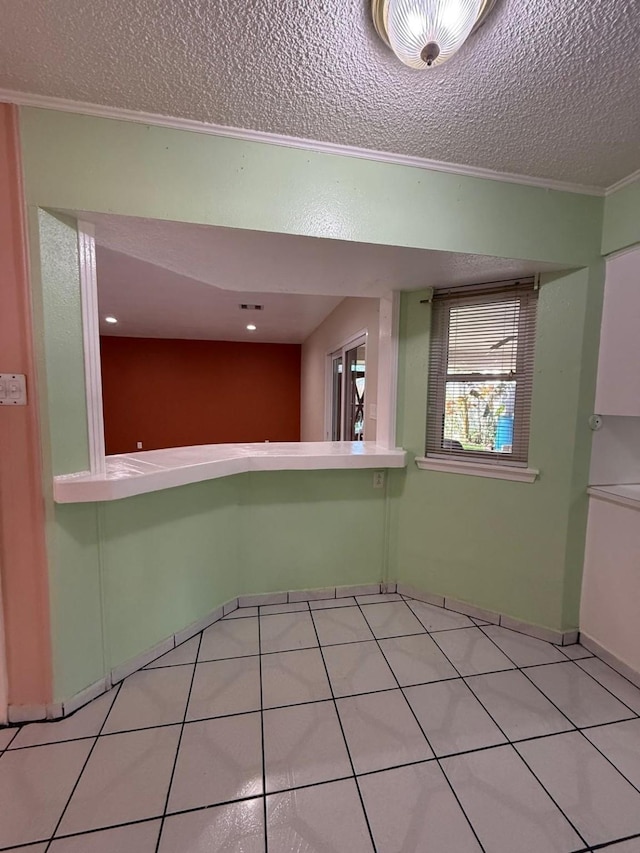 tiled empty room with a textured ceiling