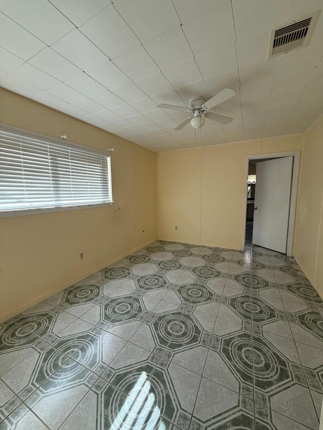 tiled spare room with ceiling fan