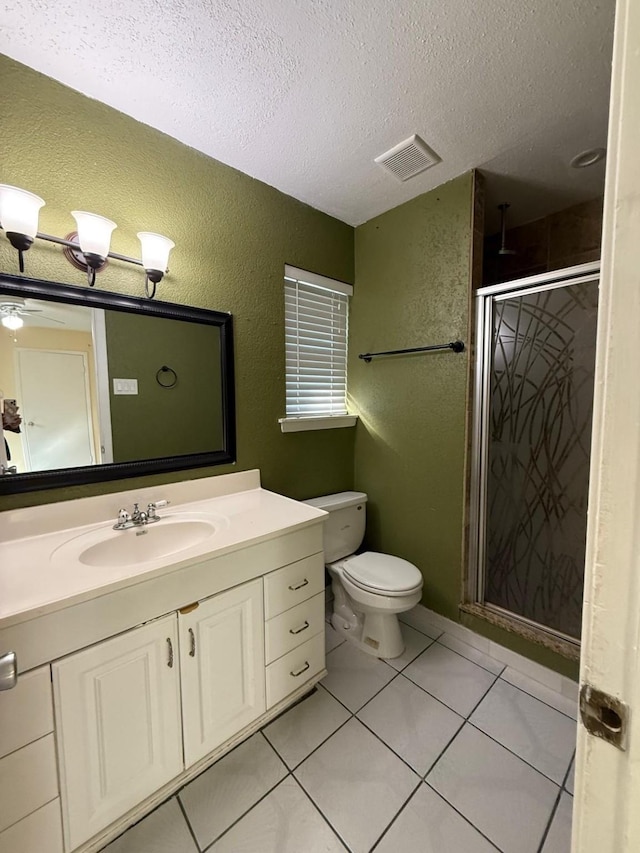 bathroom featuring a shower with shower door, tile patterned flooring, vanity, toilet, and a textured ceiling