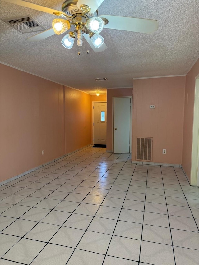 empty room featuring crown molding, a textured ceiling, ceiling fan, and light tile patterned flooring