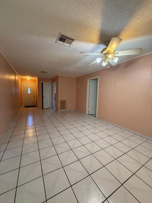 tiled empty room featuring ceiling fan and a textured ceiling