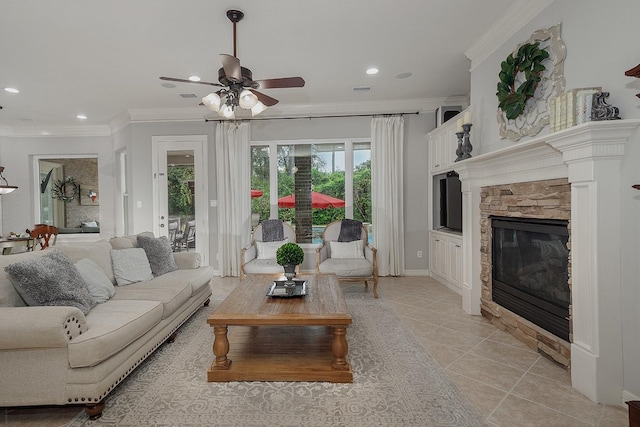 living room featuring light tile patterned floors, crown molding, a fireplace, and ceiling fan