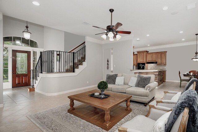 tiled living room with crown molding and ceiling fan