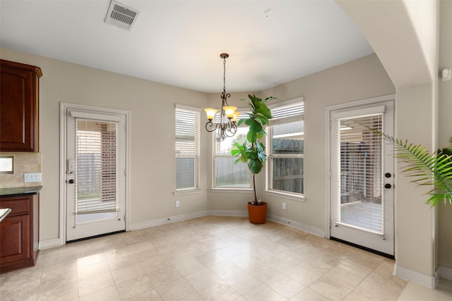 unfurnished dining area featuring a chandelier