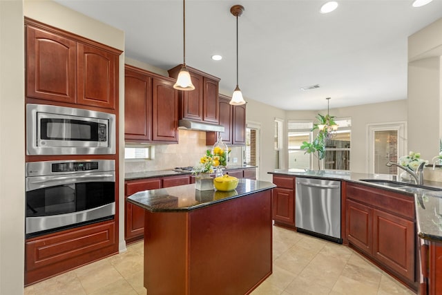 kitchen with tasteful backsplash, sink, hanging light fixtures, a center island, and stainless steel appliances