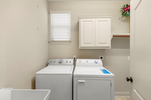 laundry room featuring cabinets, separate washer and dryer, and sink