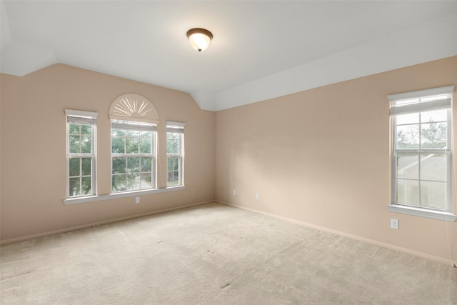 unfurnished room featuring vaulted ceiling and light carpet