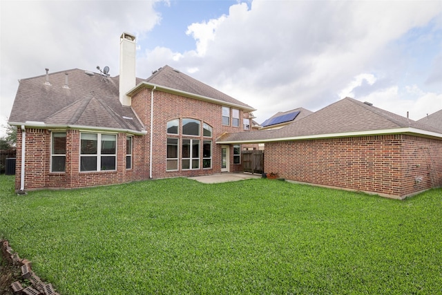 rear view of property with a yard, central AC unit, and a patio