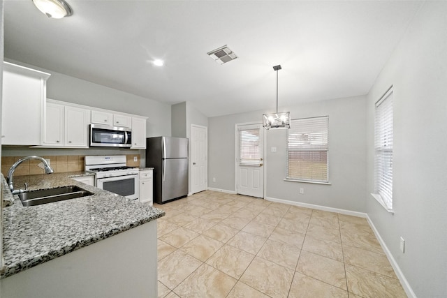 kitchen featuring white cabinetry, sink, hanging light fixtures, light stone counters, and stainless steel appliances