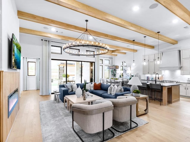 living room with beam ceiling and light wood-type flooring