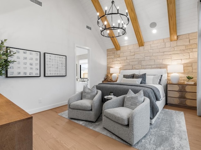 bedroom featuring connected bathroom, high vaulted ceiling, light hardwood / wood-style floors, and beamed ceiling