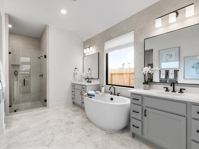 bathroom with vanity, plus walk in shower, and tile walls