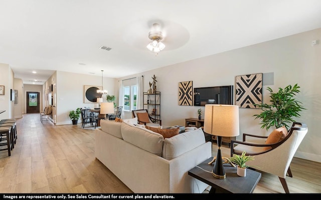 living room featuring an inviting chandelier and light hardwood / wood-style floors