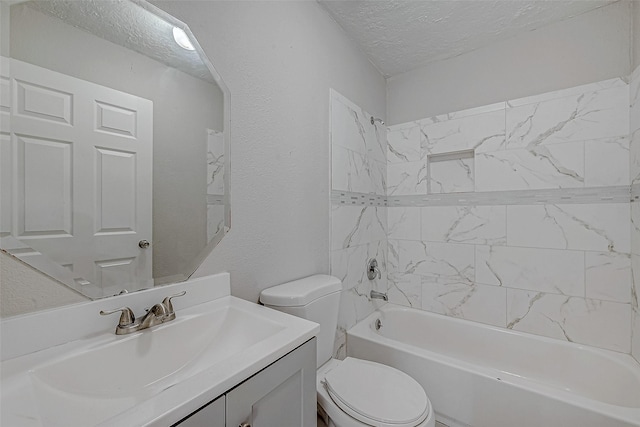 full bathroom featuring tiled shower / bath, vanity, a textured ceiling, and toilet