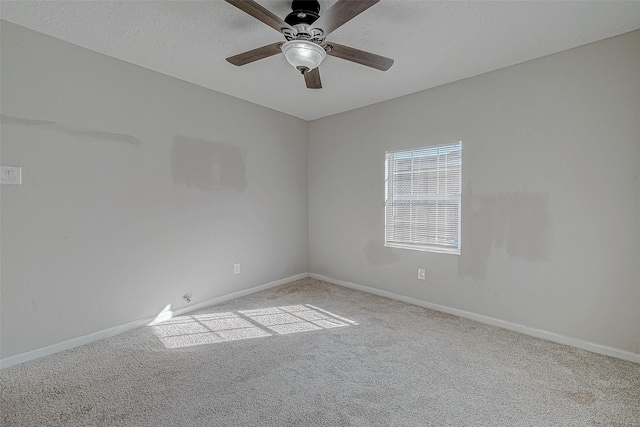 spare room featuring light colored carpet, a textured ceiling, and ceiling fan