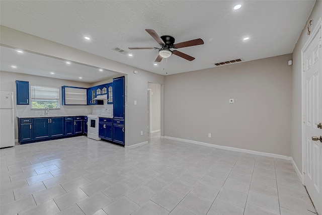 kitchen featuring sink, light tile patterned floors, ceiling fan, blue cabinetry, and white appliances