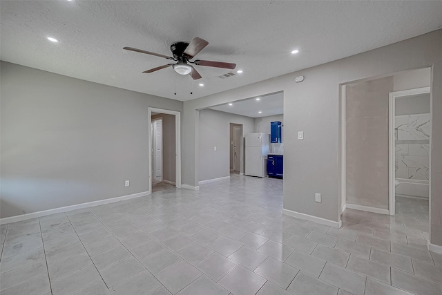 tiled spare room featuring ceiling fan and a textured ceiling