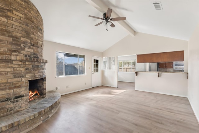 unfurnished living room with beam ceiling, wood-type flooring, high vaulted ceiling, ceiling fan, and a fireplace